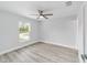 Bright, minimalist bedroom featuring a ceiling fan and a large window with natural light at 1052 Sw 158Th Ct, Ocala, FL 34481