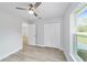 Light gray bedroom with a ceiling fan, closet, and wood-look flooring at 1052 Sw 158Th Ct, Ocala, FL 34481