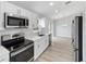 Modern kitchen with stainless steel appliances, white cabinetry, and a view of the dining area at 1052 Sw 158Th Ct, Ocala, FL 34481