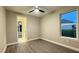 Bright bedroom with wood-look floors, ceiling fan, and natural light from the window at 17887 Sw 72Nd Street Rd, Dunnellon, FL 34432