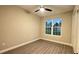 Neutral bedroom with vinyl floors, a large window and a ceiling fan, offering comfort and style at 17887 Sw 72Nd Street Rd, Dunnellon, FL 34432