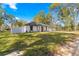 Single story home with a white exterior, gray accents, and a fenced backyard at 14152 Se 43Rd Ter, Summerfield, FL 34491