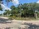 Stonecrest community entrance with lush landscaping, palm trees, and an American flag on a sunny day at 17789 Se 113Th Ter, Summerfield, FL 34491