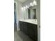 Modern bathroom features dual sinks, a large mirror, and overhead lighting at 17841 Sw 72Nd Street Rd, Dunnellon, FL 34432