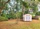 Backyard featuring a storage shed surrounded by mature trees and landscaping, offering ample space for storage at 4961 Sw 196Th Ave, Dunnellon, FL 34431