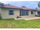 Spacious backyard with a covered patio, green lawn, and an exterior view of the home's back side at 4961 Sw 196Th Ave, Dunnellon, FL 34431