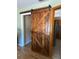 Hallway featuring an indoor barn door and wooden floors at 727 Ne 130Th Ter, Silver Springs, FL 34488