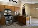 Well-lit kitchen with stainless steel appliances, granite countertops, and hanging pendant lights at 727 Ne 130Th Ter, Silver Springs, FL 34488
