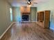 Spacious living room featuring a brick fireplace, wood floors, and a wooden entertainment center at 727 Ne 130Th Ter, Silver Springs, FL 34488