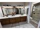 Well-lit main bathroom with double sinks, a large mirror, and a walk-in shower at 727 Ne 130Th Ter, Silver Springs, FL 34488