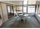 Enclosed patio with white plastic table set and many windows at 727 Ne 130Th Ter, Silver Springs, FL 34488
