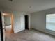 Bedroom features neutral carpet, a window, and a closet with a view to an adjacent room at 9115 Sw 49Th Ct, Ocala, FL 34476
