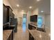 Kitchen features dark cabinets, stainless steel appliances, granite countertops, and tile flooring at 9115 Sw 49Th Ct, Ocala, FL 34476