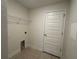 Laundry room with tile flooring, a wire shelf, hookups, and a white door at 9115 Sw 49Th Ct, Ocala, FL 34476