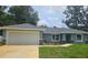 Charming single-story home with a two-car garage, manicured lawn, and lovely landscaping at 15067 Se 61St Ct, Summerfield, FL 34491
