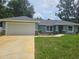 Inviting one-story home featuring a well-manicured lawn and a convenient two-car garage at 15067 Se 61St Ct, Summerfield, FL 34491