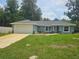 Charming single-story home with a lush green lawn and a two-car garage at 15067 Se 61St Ct, Summerfield, FL 34491