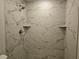 Close-up of a shower with marble-style tile and built-in shelves at 15067 Se 61St Ct, Summerfield, FL 34491