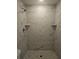 Walk-in shower featuring sleek, modern, floor-to-ceiling marble tile at 15067 Se 61St Ct, Summerfield, FL 34491