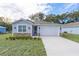 Newly constructed home with gray siding, stone accents, and a two-car garage at 13850 Se 42Nd Ave, Summerfield, FL 34491