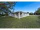 Side view of the house showing a covered patio and grassy backyard at 13850 Se 42Nd Ave, Summerfield, FL 34491