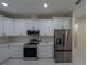 Modern kitchen featuring stainless steel appliances and white cabinetry at 13850 Se 42Nd Ave, Summerfield, FL 34491