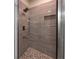 Large shower with gray tile and built-in seat at 13850 Se 42Nd Ave, Summerfield, FL 34491