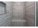 Spacious shower with gray tile and built-in seat at 13850 Se 42Nd Ave, Summerfield, FL 34491