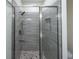 Modern shower with gray tiles and glass enclosure at 13850 Se 42Nd Ave, Summerfield, FL 34491