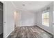 Cozy bedroom featuring neutral tones, wood-look floors, and a bright window at 11837 Se 165 Ave, Ocklawaha, FL 32179