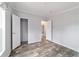 Bedroom features wood-look flooring, gray walls, closet, and views of another room at 11837 Se 165 Ave, Ocklawaha, FL 32179