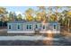 Inviting single-story home with gray siding and a welcoming front porch, nestled among lush trees at 11837 Se 165 Ave, Ocklawaha, FL 32179