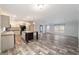 Open-concept living room featuring hardwood flooring, a center island, modern lighting, and neutral paint palette at 11837 Se 165 Ave, Ocklawaha, FL 32179