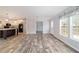 Bright living room with an open layout, featuring wood-look flooring, and adjacent kitchen at 11837 Se 165 Ave, Ocklawaha, FL 32179