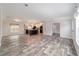 Open living room showcasing wood-look floors, natural light, and adjacent modern kitchen at 11837 Se 165 Ave, Ocklawaha, FL 32179