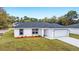 New construction home boasts a well-manicured lawn, modern gray trim and fresh landscaping at 13848 Sw 102 St, Dunnellon, FL 34432