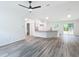 Bright, open-concept living room with modern flooring, a kitchen island, and ample natural light at 24780 Nw Hillsdale Ave, Dunnellon, FL 34431