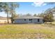 A well manicured backyard with a large grassy area and small patio ready for entertaining and recreation at 13212 Sw 113 Ln, Dunnellon, FL 34432