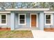Inviting front porch featuring a modern exterior door, fresh paint, and well-manicured landscaping at 13212 Sw 113 Ln, Dunnellon, FL 34432