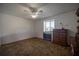 Bedroom features carpet flooring, ceiling fan, natural lighting, and a dark wood dresser at 10817 Se 51St Ave, Belleview, FL 34420