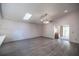 Bright living room featuring vaulted ceilings, a ceiling fan, a skylight and wood-look flooring creating a modern and airy atmosphere at 10817 Se 51St Ave, Belleview, FL 34420