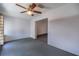 A cozy living room with soft gray carpet and a decorative ceiling fan at 10817 Se 51St Ave, Belleview, FL 34420