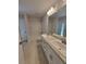 Well-lit bathroom features double sink vanity with granite counters, shower-tub combo and wood-style floors at 11610 Sw 59Th Terrace, Ocala, FL 34476