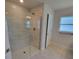 Modern bathroom with a glass-enclosed shower, neutral tile, and ample natural light at 11610 Sw 59Th Terrace, Ocala, FL 34476