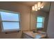 Bright bathroom featuring a granite countertop, large mirror, and a window for natural light at 11610 Sw 59Th Terrace, Ocala, FL 34476