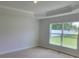 Neutral bedroom with a tray ceiling, a large window and a closet at 11610 Sw 59Th Terrace, Ocala, FL 34476