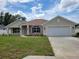 Charming single-story home featuring a well-maintained lawn, attached two-car garage, and neutral exterior paint at 11610 Sw 59Th Terrace, Ocala, FL 34476