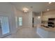 Bright kitchen connected to a living area, featuring white cabinetry, granite countertops, and stainless steel appliances at 11610 Sw 59Th Terrace, Ocala, FL 34476