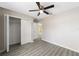 Bedroom with luxury vinyl plank flooring, ceiling fan, closet, and neutral paint at 3165 Se 147Th Ln, Summerfield, FL 34491