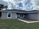 Two-story home with gray siding, stone accents, and a partially landscaped yard at 90 Bay Dr, Ocklawaha, FL 32179